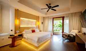 Et moderne soveværelse med en stor seng, siddepladser og en åben balkon med udsigt over grønt. (AI-genereret tekst)