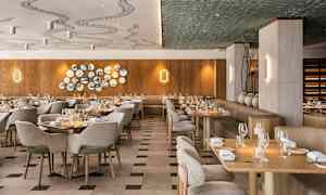 En elegant restaurant med træpaneler, smagfuld indretning og dækkede borde. (AI-genereret tekst)