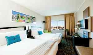 Hotelværelse med to enkeltsenge, en vinduesudsigt og moderne indretning. (AI-genereret tekst)