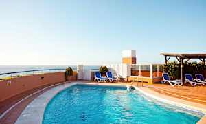 Udendørs pool med liggestole og havudsigt. (AI-genereret tekst)