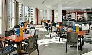 Restaurant med borde og stole på et lyst gulv. (AI-genereret tekst)