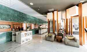 En hotellobby med siddeområder og en receptionsdisk. (AI-genereret tekst)