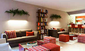 En moderne stue med sofaer, en bogreol og en bardisk i baggrunden. (AI-genereret tekst)