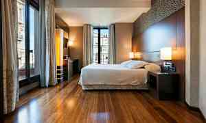 Et moderne soveværelse med en stor seng og store vinduer, der lukker masser af lys ind. (AI-genereret tekst)