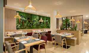 En moderne restaurant med træmøbler og grønne planter som dekoration. (AI-genereret tekst)