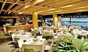 Restaurantinteriør med dækkede borde og dekorative blomster. (AI-genereret tekst)