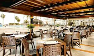 Restaurant med siddepladser udendørs ved poolområdet. (AI-genereret tekst)