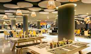 Elegant restaurant med moderne indretning, med bænke og borde dekoreret med små planter. (AI-genereret tekst)