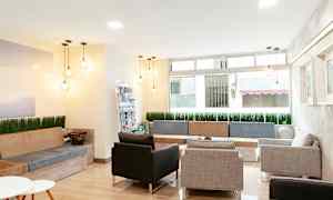 Et moderne møbleret venteværelse med sofaer, stole og dekorative lamper. (AI-genereret tekst)