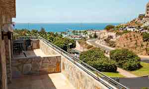 Billede af en balkon med udsigt over havet og landskabet. (AI-genereret tekst)