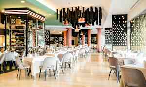 Elegant hotelrestaurant med dækkede borde og moderne indretning. (AI-genereret tekst)