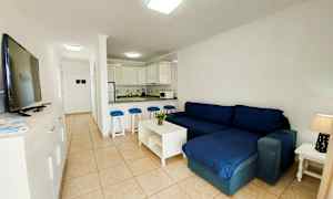 En stue med mørkeblå sofa og åbent køkken. (AI-genereret tekst)