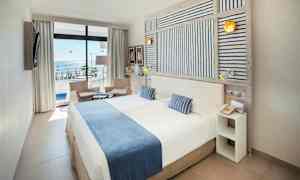 Dobbeltværelse med havudsigt, møbler i lyse farver. (AI-genereret tekst)