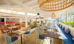 En åben restaurant med borde og stole samt havudsigt. (AI-genereret tekst)