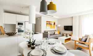 En moderne stue med køkkenområde, spisebord og sofa. (AI-genereret tekst)