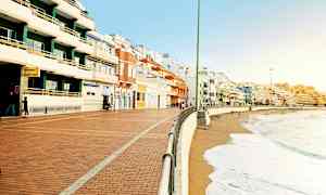 En strandpromenade med farverige bygninger langs kysten. (AI-genereret tekst)