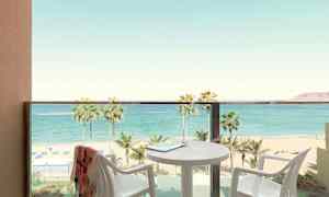 Altan med udsigt over strand og hav, bord og stole er synlige. (AI-genereret tekst)