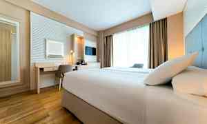 Et hotelværelse med en seng, skrivebord og vindue. (AI-genereret tekst)