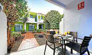 Udendørsområde med siddepladser og frodig omgivelser. (AI-genereret tekst)