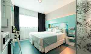 Et moderne hotelværelse med en dobbeltseng, lyse farver og havtema. (AI-genereret tekst)