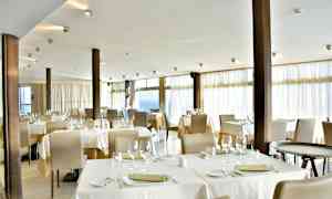 Billede af en restaurant med dækkede borde og stole. (AI-genereret tekst)