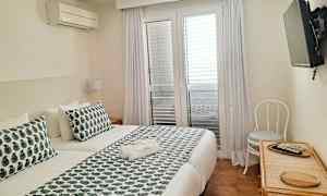 Et hotelværelse med en dobbeltseng og et vægmonteret TV. (AI-genereret tekst)