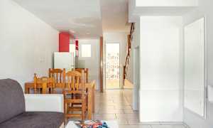 Et rum med sofa, spisebord og køkkengrej. (AI-genereret tekst)