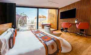 Moderne hotelværelse med dobbeltseng, skrivebord, siddepladser og adgang til en terrasse med havemøbler og spabad. (AI-genereret tekst)