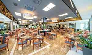 Stort restaurantområde med mange borde og stole. (AI-genereret tekst)