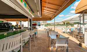 Udendørsservering med borde og stole ved en pool. (AI-genereret tekst)