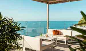 Moderne terrasse med møbler og havudsigt. (AI-genereret tekst)