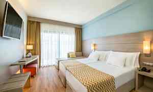 Dobbeltværelse med moderne indretning, lyse farver og en stor seng. (AI-genereret tekst)