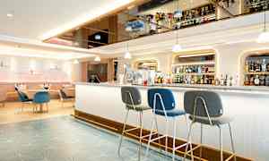 Moderne hotelbar med siddepladser og hylder fyldt med flasker. (AI-genereret tekst)