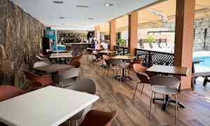 En rummelig udendørs servering med borde og stole ved en pool. (AI-genereret tekst)