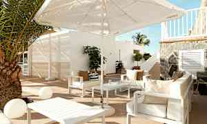 Udendørs loungemøbler med sofaer, parasol og et bord på en terrasse. (AI-genereret tekst)