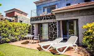 Billede af en terrasse med liggestole og siddepladser ved et hus. (AI-genereret tekst)