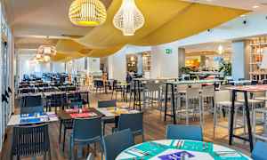 Interiør af en restaurant med opdækkede borde og stole. (AI-genereret tekst)