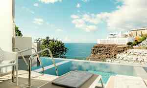 En privat pool med havudsigt og nærliggende hotellbygninger. (AI-genereret tekst)