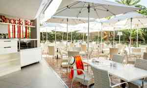 Udendørs servering med borde og stole under parasoller. (AI-genereret tekst)