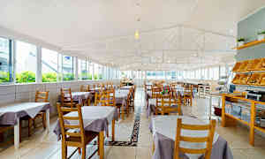 En rummelig restaurant med borde dækket med lilla og hvide duge. (AI-genereret tekst)