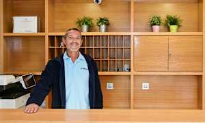 Reception med træinteriør, planter og nøgleskab. (AI-genereret tekst)