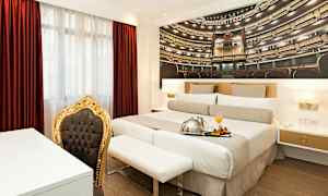 Værelse med dobbeltseng, rødt gardin og en stol med guldramme. (AI-genereret tekst)