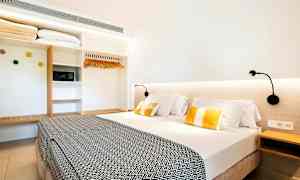 Hotelværelse med en dobbeltseng, sengelamper og et garderobeskab. (AI-genereret tekst)