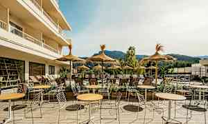 Udendørsområde med borde, stole og parasoller ved en solrig terrasse. (AI-genereret tekst)