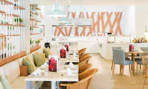 Åbent restaurantområde med borde, stole og dekorative træpaneler. (AI-genereret tekst)