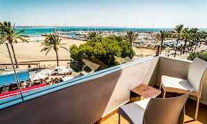 Udsigt fra en altan mod stranden, palmer og en havn med både. (AI-genereret tekst)