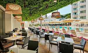 Udendørsservering med borde og stole, ved siden af en pool og liggestole under parasoller. (AI-genereret tekst)