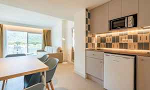 Moderne køkken og stue med udsigt mod altan og bjerge. (AI-genereret tekst)