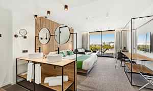 Moderne hotelværelse med dobbeltseng, siddeområde og badeværelse. (AI-genereret tekst)