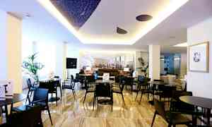 Et moderne interiørområde med sorte borde og stole, dekorative planter og en lys atmosfære. (AI-genereret tekst)